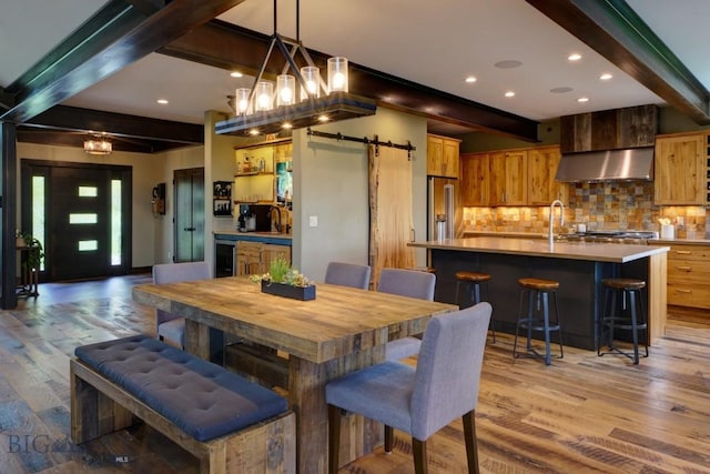 65 Triple Tree Ln, Bozeman, MT 59715 - dining room featuring beam ceiling, a barn door, light wood-type flooring, wine cooler, and recessed lighting