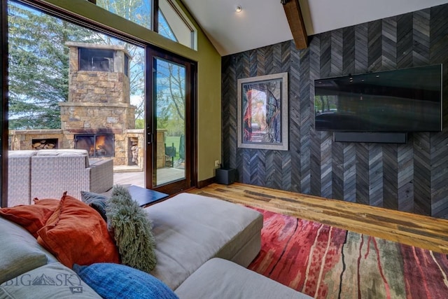 65 Triple Tree Ln, Bozeman, MT 59715 - bedroom featuring access to outside, wood finished floors, a stone fireplace, and an accent wall
