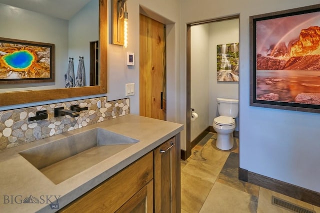 65 Triple Tree Ln, Bozeman, MT 59715 - bathroom with vanity, toilet, and decorative backsplash