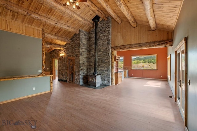 1511 Mt Highway 287, Virginia City, MT 59755 - unfurnished living room featuring a wood stove, wood finished floors, wood ceiling with exposed beams, high vaulted ceiling, and a ceiling fan