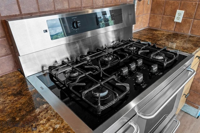 1511 Mt Highway 287, Virginia City, MT 59755 - kitchen view of stainless steel range with gas cooktop, decorative backsplash, and dark stone countertops