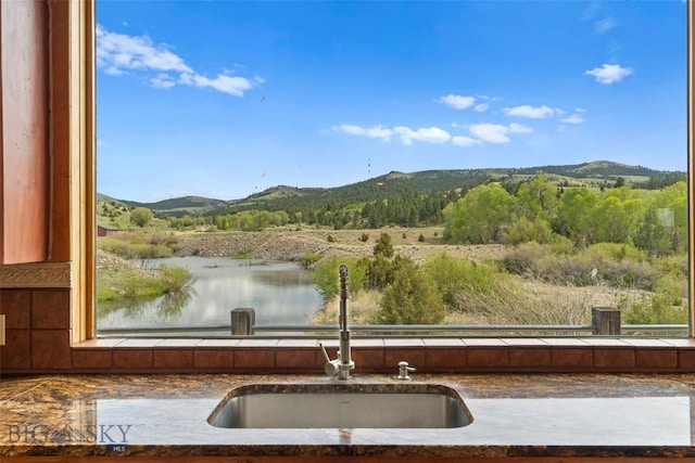 1511 Mt Highway 287, Virginia City, MT 59755 - kitchen view of a sink, a mountain backdrop, backsplash, and dark countertops