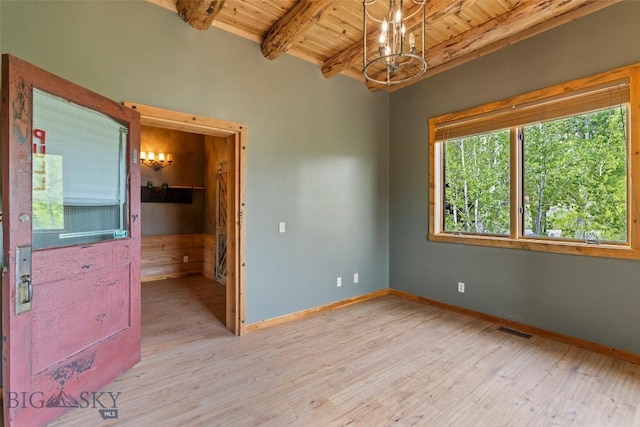 1511 Mt Highway 287, Virginia City, MT 59755 - empty room featuring wood ceiling with exposed beams, a chandelier, light wood-style flooring, and baseboards
