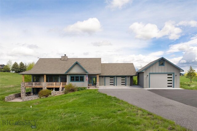 101 Columbine Ct, Bozeman, MT 59715 - view of front of property with a chimney, a front yard, a detached garage, a shingled roof, and asphalt driveway