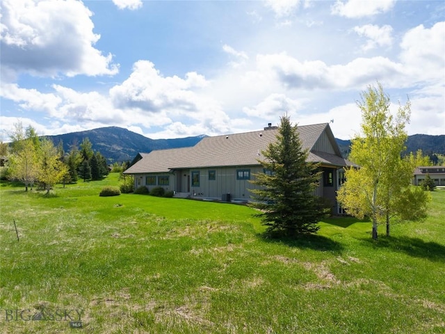 101 Columbine Ct, Bozeman, MT 59715 - rear view of property with board and batten siding, a mountain view, and a yard