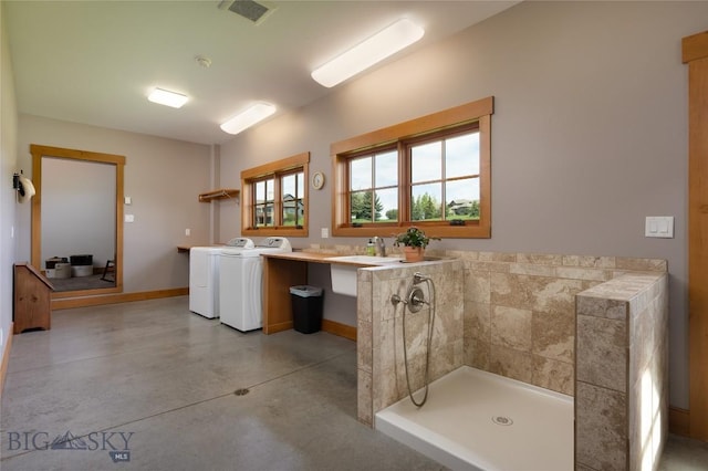 101 Columbine Ct, Bozeman, MT 59715 - bathroom featuring washer and clothes dryer, finished concrete floors, a tile shower, baseboards, and vanity