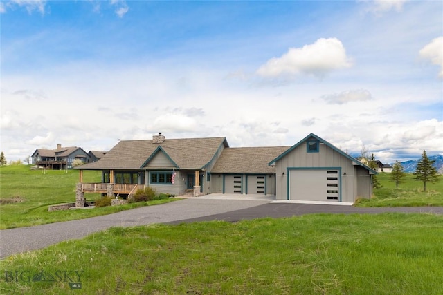 101 Columbine Ct, Bozeman, MT 59715 - view of front of property with driveway, a garage, a front lawn, and a chimney