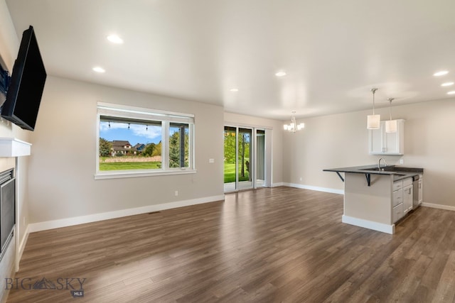 3123 Warbler Way Units A-D, Units A-D Bozeman, MT 59718 - unfurnished living room with a chandelier, dark wood finished floors, recessed lighting, baseboards, and a glass covered fireplace