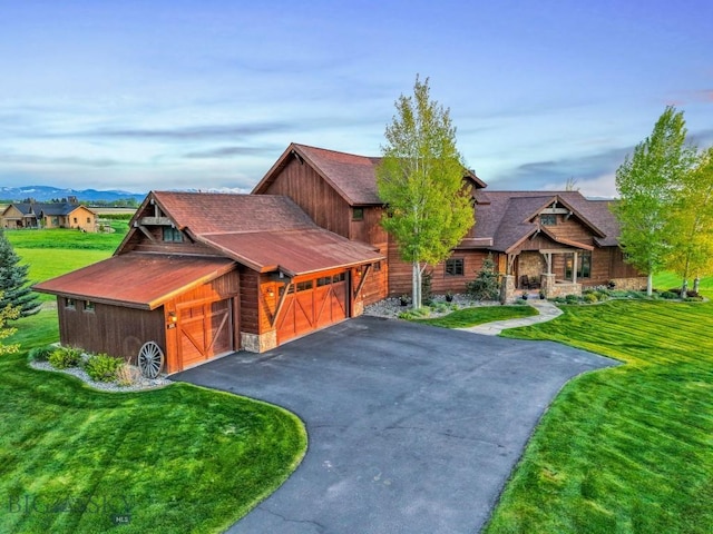 171 Brave Heart Loop, Bozeman, MT 59718 - view of front of property featuring stone siding, a front yard, driveway, and a garage