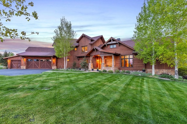 171 Brave Heart Loop, Bozeman, MT 59718 - view of front of home with stone siding, a lawn, an attached garage, and driveway
