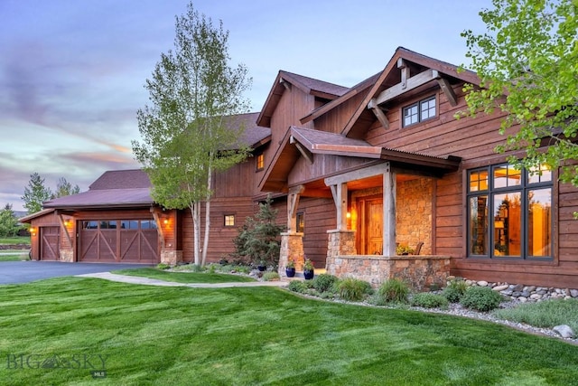 171 Brave Heart Loop, Bozeman, MT 59718 - view of front of house with driveway, stone siding, a yard, and a garage