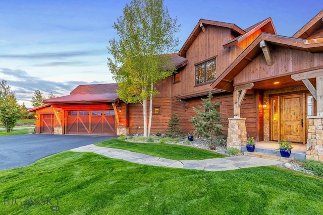 171 Brave Heart Loop, Bozeman, MT 59718 - view of front of property with stone siding, a front lawn, an attached garage, and asphalt driveway