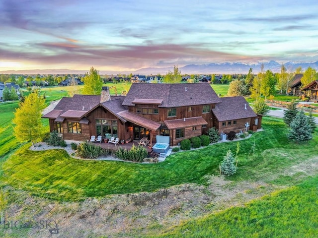 171 Brave Heart Loop, Bozeman, MT 59718 - rear view of property featuring a chimney, a patio, a lawn, and roof with shingles