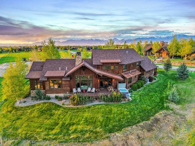 171 Brave Heart Loop, Bozeman, MT 59718 - back of property with a chimney, a yard, a mountain view, and roof with shingles