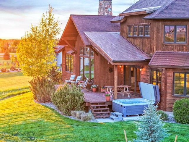 171 Brave Heart Loop, Bozeman, MT 59718 - back of property with a deck, a chimney, a shingled roof, a hot tub, and metal roof