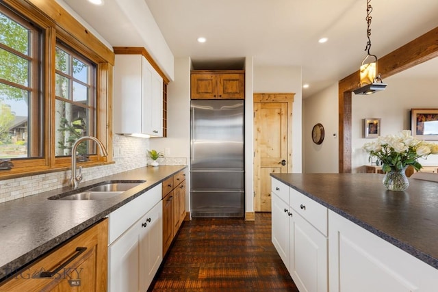 171 Brave Heart Loop, Bozeman, MT 59718 - kitchen with built in refrigerator, dark countertops, a sink, decorative backsplash, and recessed lighting