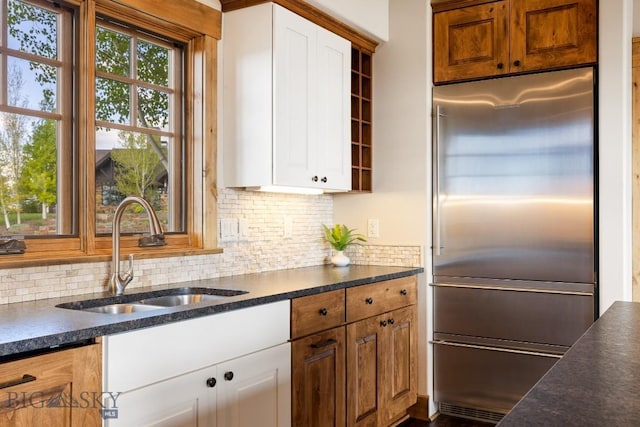 171 Brave Heart Loop, Bozeman, MT 59718 - kitchen featuring stainless steel built in fridge, a sink, decorative backsplash, and white cabinets