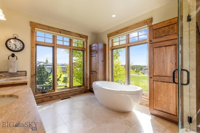 171 Brave Heart Loop, Bozeman, MT 59718 - full bath featuring a soaking tub, a shower stall, vanity, and tile patterned floors
