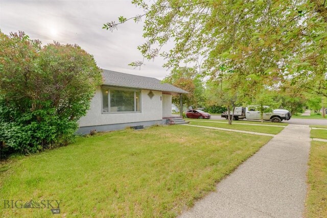 602 1st Ave E, Three Forks, MT 59752 - view of home's exterior featuring stucco siding and a yard