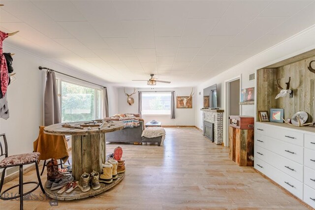 602 1st Ave E, Three Forks, MT 59752 - dining area with light wood-style floors, a glass covered fireplace, and a ceiling fan