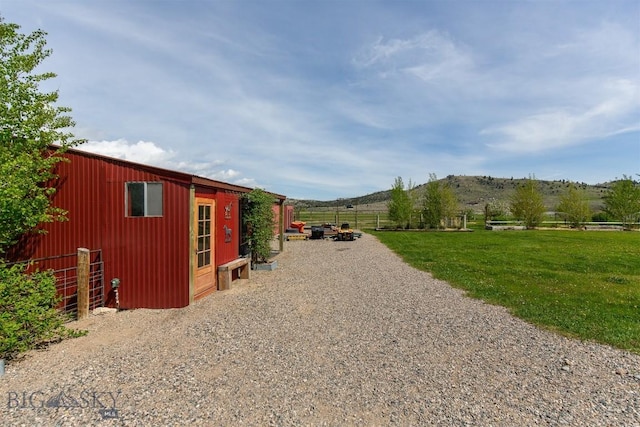 49 Redtail Hawk Rd, Mcallister, MT 59740 - view of side of home with an outbuilding, a mountain view, and driveway