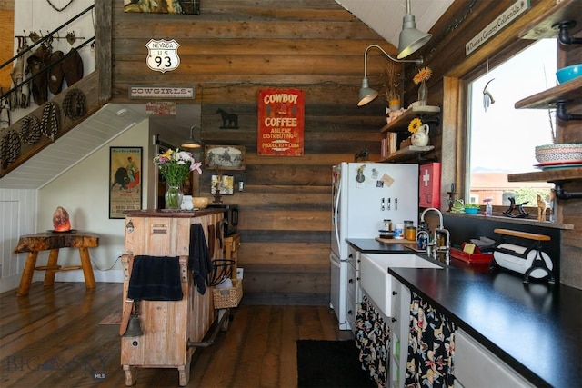 49 Redtail Hawk Rd, Mcallister, MT 59740 - kitchen with dark wood-style flooring, lofted ceiling, dark countertops, rustic walls, and a sink
