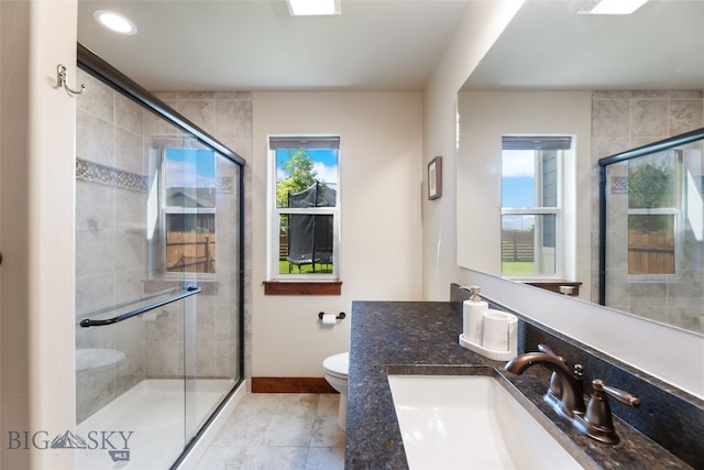4426 Ethan Way, Bozeman, MT 59718 - bathroom featuring toilet, a stall shower, vanity, and baseboards