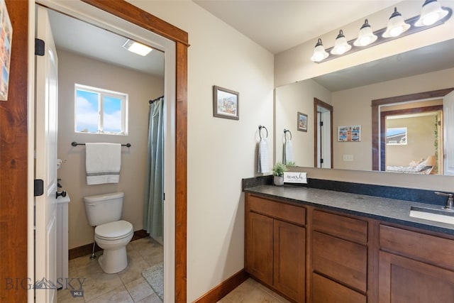 4426 Ethan Way, Bozeman, MT 59718 - bathroom featuring toilet, vanity, tile patterned floors, and baseboards