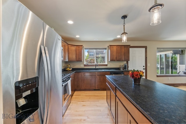 4426 Ethan Way, Bozeman, MT 59718 - kitchen featuring appliances with stainless steel finishes, light wood-type flooring, a sink, pendant lighting, and brown cabinets
