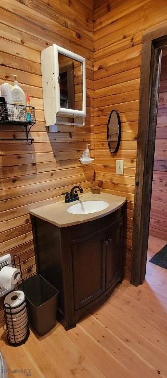 747 Upper Ruby Rd, Alder, MT 59755 - bathroom featuring wood walls, vanity, and hardwood / wood-style floors