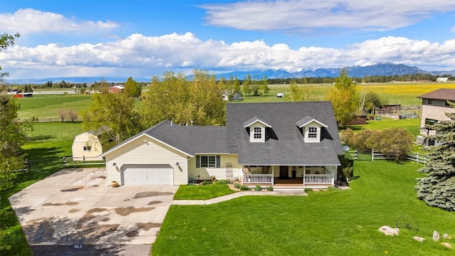 125 N Pheasant Dr, Bozeman, MT 59718 - new england style home featuring a porch, a garage, driveway, a mountain view, and a shingled roof