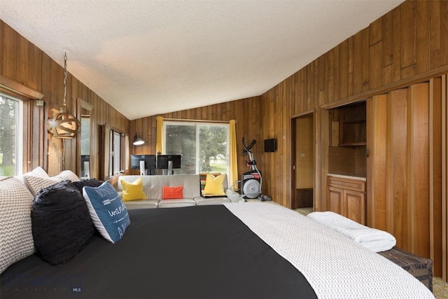 1930 Yellowtail, Big Sky, MT 59716 - bedroom with wooden walls, lofted ceiling, carpet flooring, and a textured ceiling