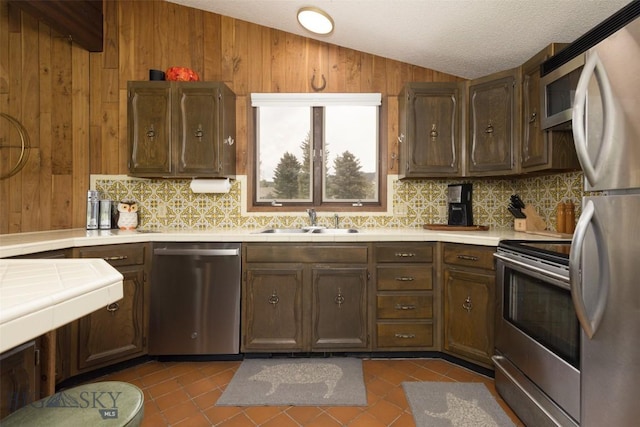 1930 Yellowtail, Big Sky, MT 59716 - kitchen with stainless steel appliances, lofted ceiling, a sink, tile counters, and backsplash