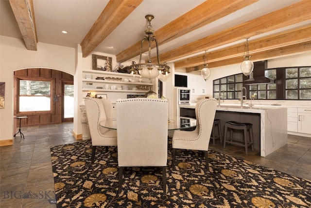 45 Cutthroat Trout, Big Sky, MT 59716 - dining area featuring stone tile flooring, beamed ceiling, healthy amount of natural light, and arched walkways