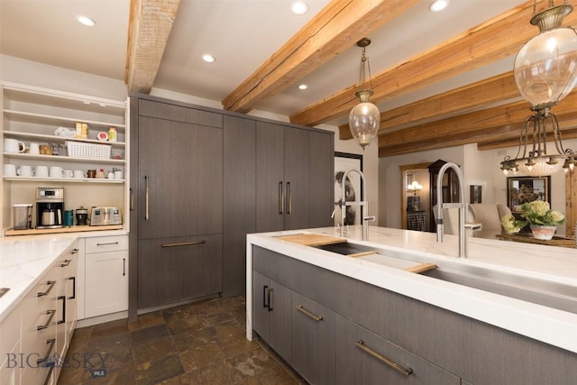 45 Cutthroat Trout, Big Sky, MT 59716 - kitchen featuring beam ceiling, dark stone finish floors, hanging light fixtures, recessed lighting, and light stone countertops