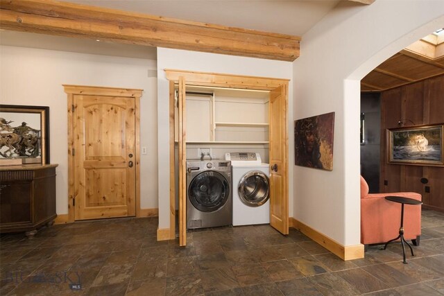 45 Cutthroat Trout, Big Sky, MT 59716 - laundry area featuring separate washer and dryer, arched walkways, baseboards, and dark stone finish floors