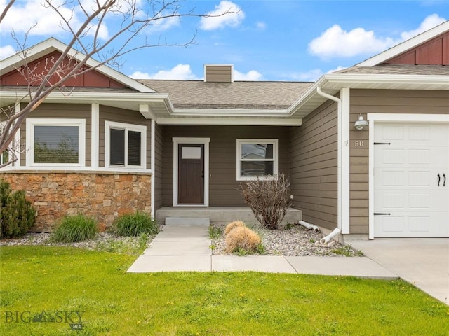 50 Pattee Trl, Bozeman, MT 59718 - entrance to property featuring a chimney, a lawn, a shingled roof, an attached garage, and stone siding