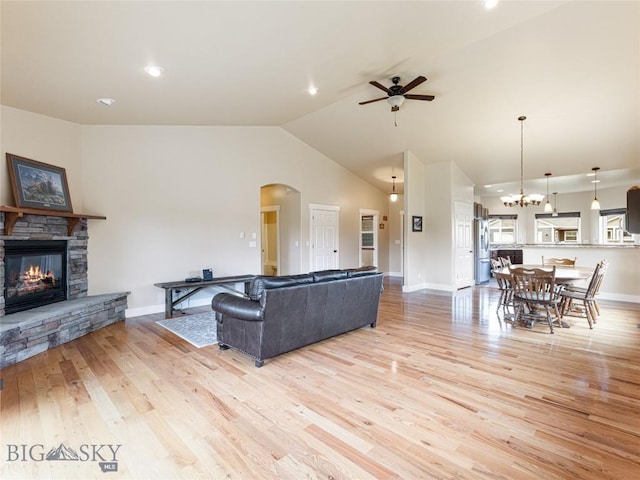 50 Pattee Trl, Bozeman, MT 59718 - living area with a ceiling fan, arched walkways, a stone fireplace, light wood-type flooring, and lofted ceiling