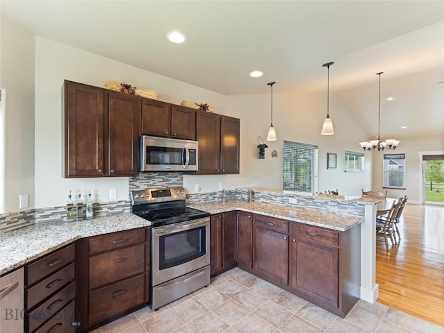 50 Pattee Trl, Bozeman, MT 59718 - kitchen with stainless steel appliances, a peninsula, a chandelier, dark brown cabinets, and light stone counters
