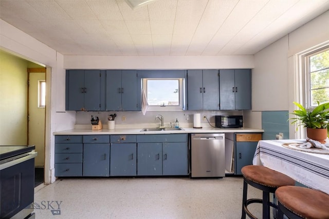 411 W Railroad Ave N, Manhattan, MT 59741 - kitchen with a sink, appliances with stainless steel finishes, blue cabinetry, light countertops, and dark aggregate flooring
