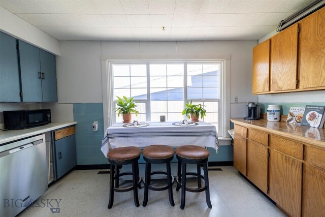 411 W Railroad Ave N, Manhattan, MT 59741 - kitchen featuring black microwave, dishwasher, light countertops, and brown cabinetry