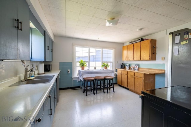 411 W Railroad Ave N, Manhattan, MT 59741 - kitchen with a sink, brown cabinets, light countertops, and light floors