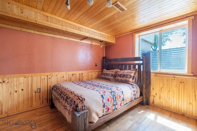 411 W Railroad Ave N, Manhattan, MT 59741 - bedroom with wooden ceiling, wood walls, wood-type flooring, and a wainscoted wall