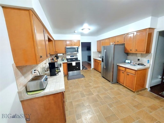 2040 Adams, Butte, MT 59701 - kitchen with stainless steel appliances, decorative backsplash, tile countertops, and brown cabinets