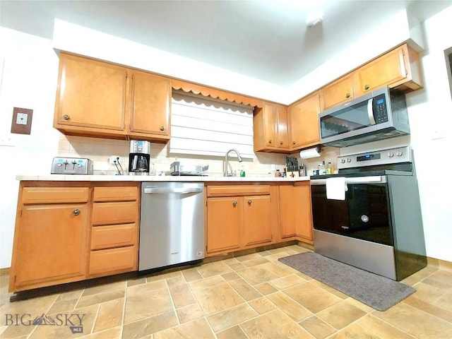 2040 Adams, Butte, MT 59701 - kitchen featuring appliances with stainless steel finishes, light countertops, light stone finish floors, a sink, and backsplash