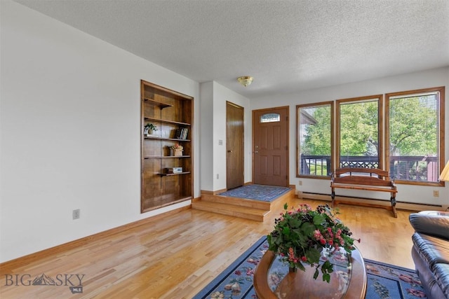 1385 Baldy Mountain Ln, Belgrade, MT 59714 - entrance foyer with a textured ceiling, wood finished floors, baseboard heating, and baseboards