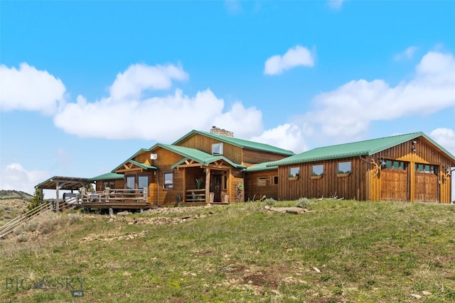 125 Rocky Mountain Mdws, Bozeman, MT 59715 - rear view of property with a chimney, metal roof, and a wooden deck