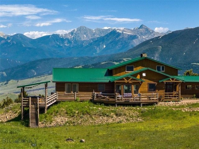 125 Rocky Mountain Mdws, Bozeman, MT 59715 - back of property with a deck with mountain view, metal roof, and a chimney