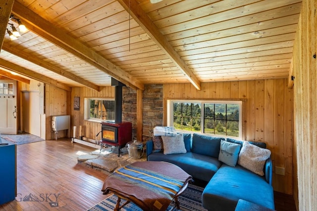 125 Rocky Mountain Mdws, Bozeman, MT 59715 - living area featuring a wood stove, wood ceiling with exposed beams, wood walls, and wood-type flooring