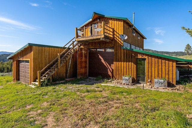 125 Rocky Mountain Mdws, Bozeman, MT 59715 - rear view of house with board and batten siding, stairs, and a detached garage